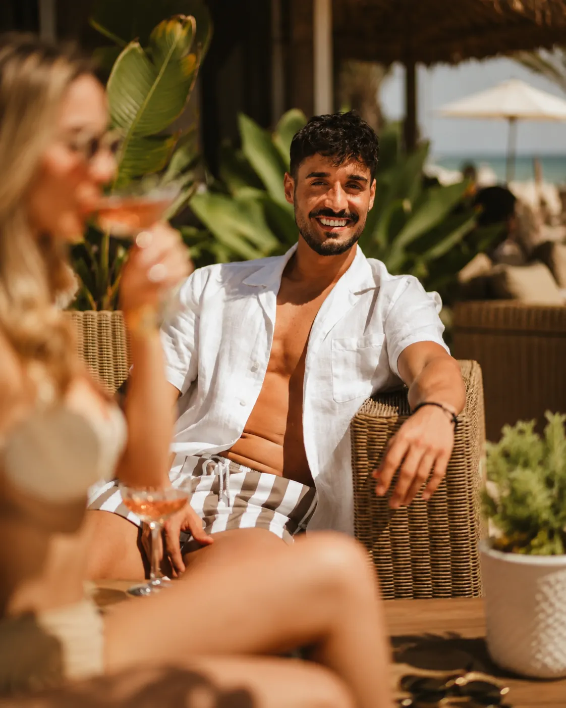 Guest relaxing with a drink at Nikki Beach Marbella lounge terrace