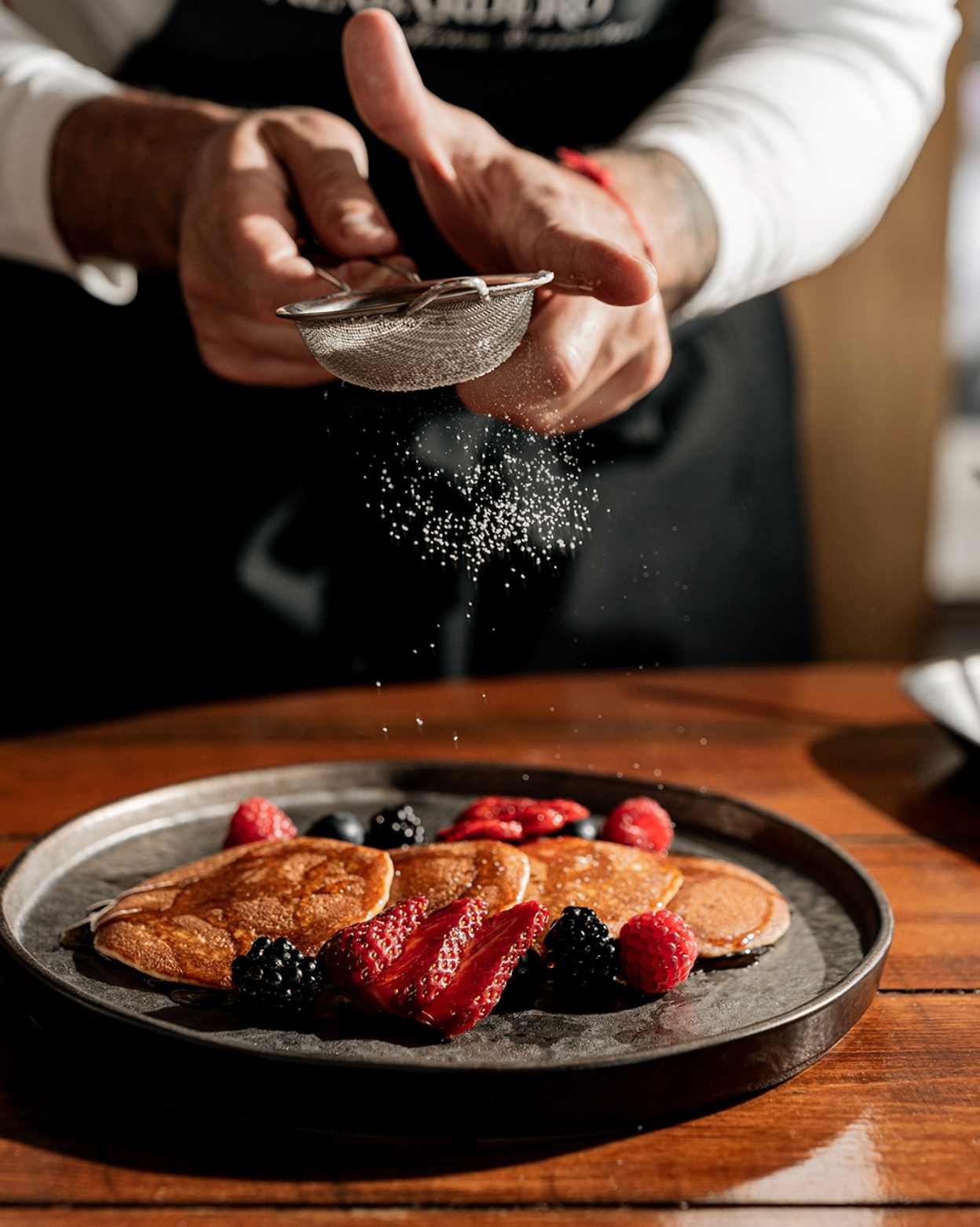 Breakfast-style plate with berries being finished tableside at Alabardero Beach Club