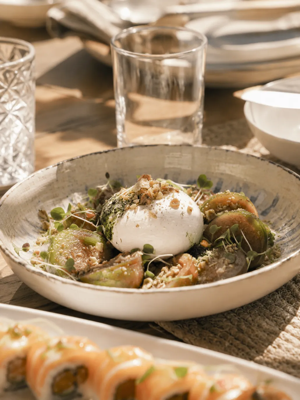 Food served at Bono Beach Marbella including burrata and sushi plates