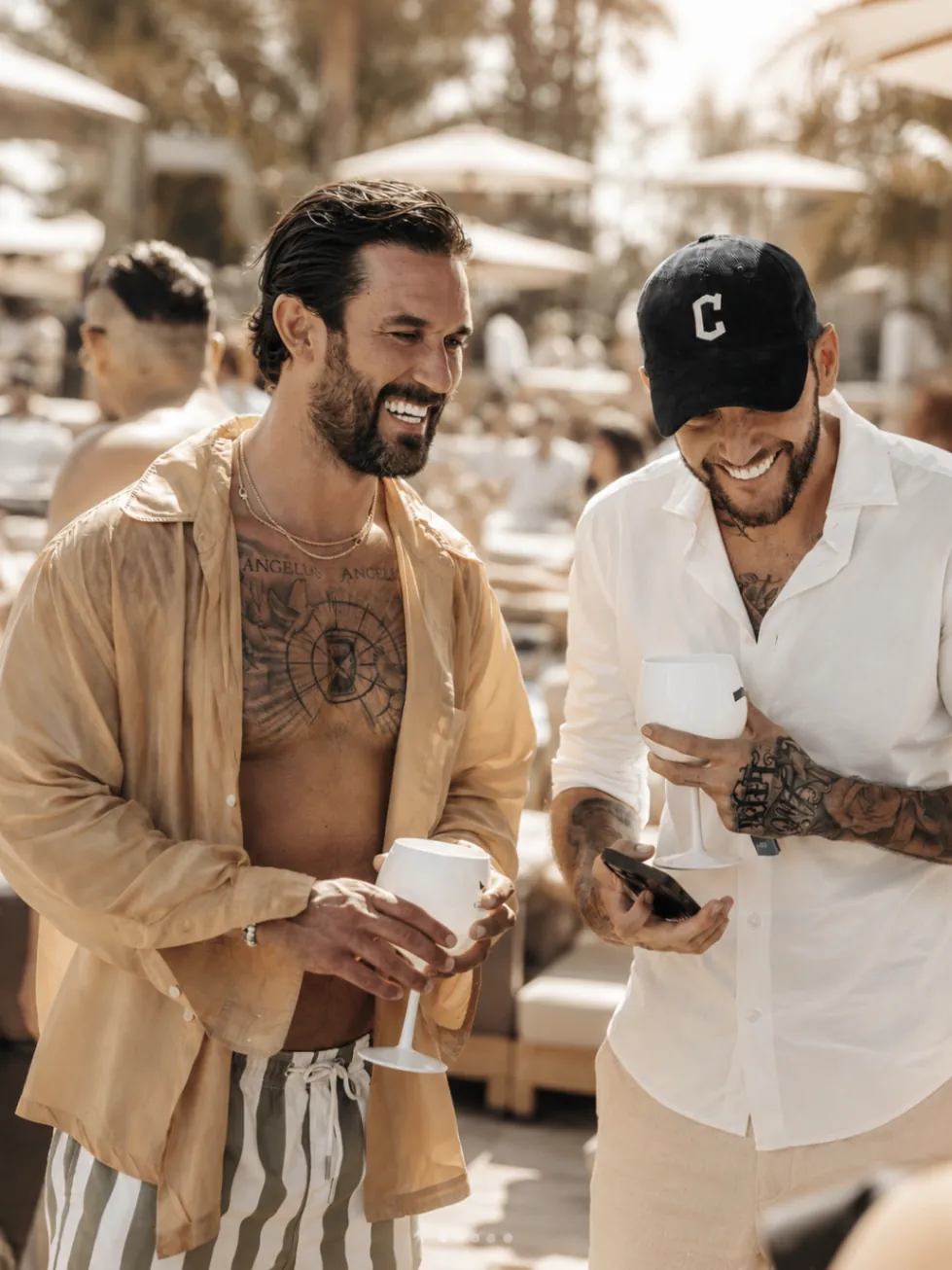 Guests chatting with drinks beside the pool at Nao Pool Club Marbella