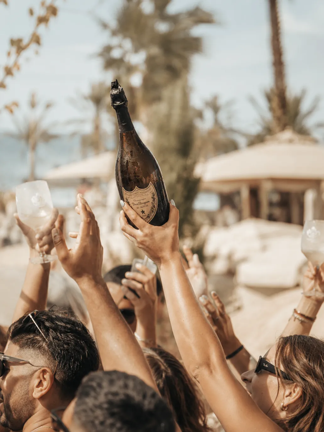 Champagne bottle service raised above the crowd at Nao Pool Club Marbella