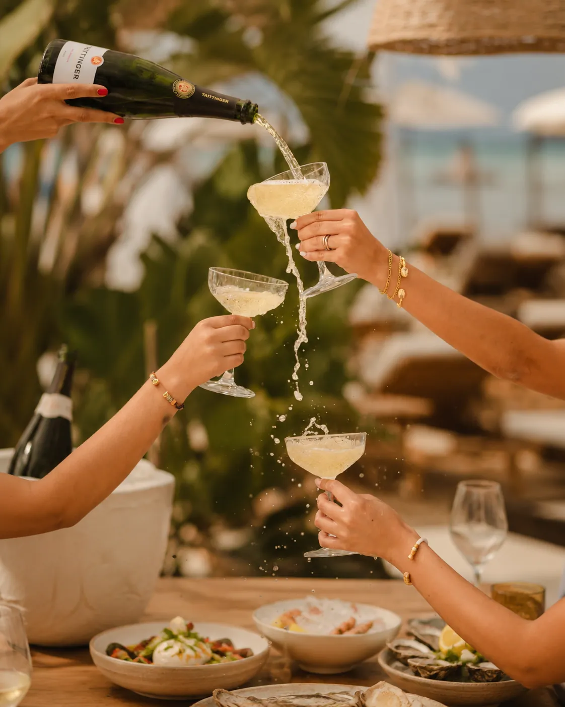 Champagne being poured between guests at Nikki Beach Marbella