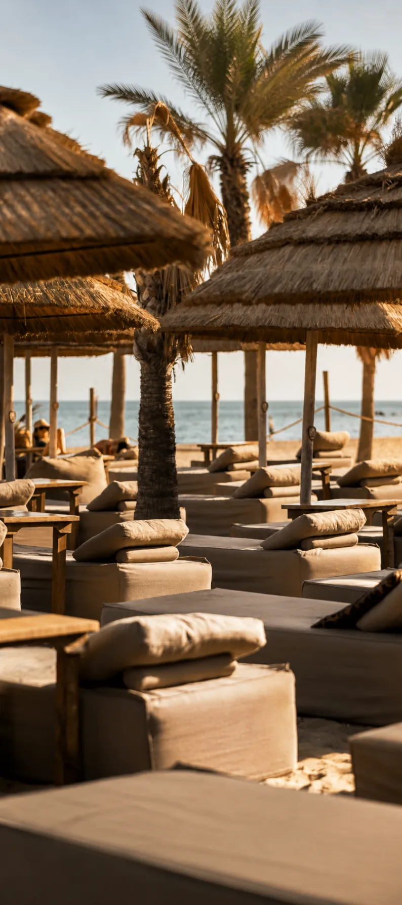 Playa Padre Marbella sunbeds and straw parasols facing the sea in late-afternoon light