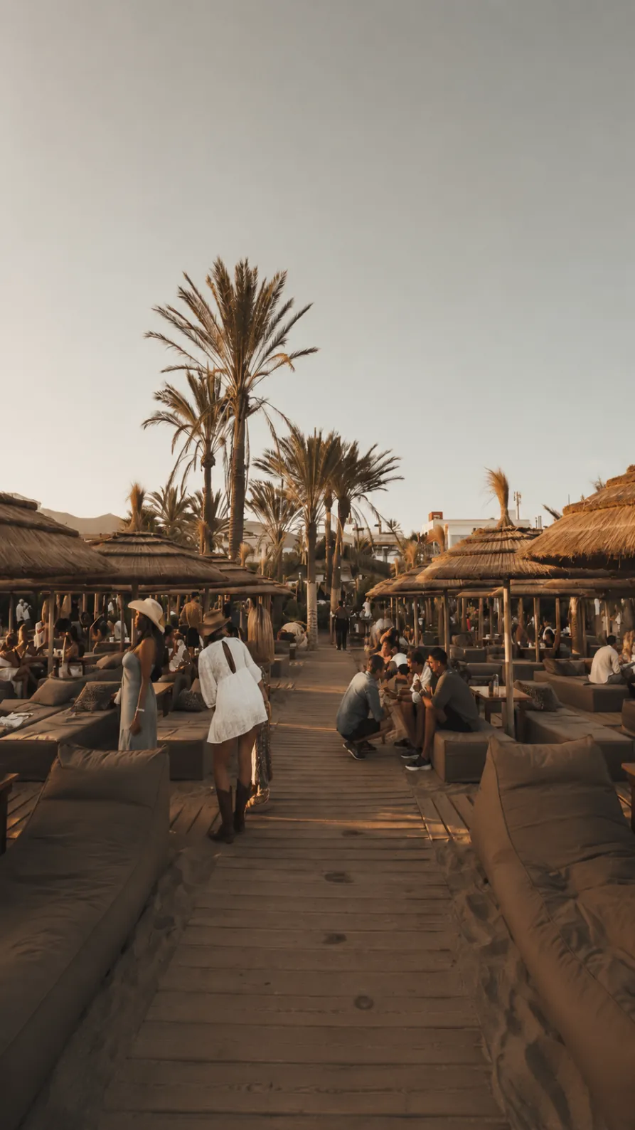 Central wooden walkway through the sunbed area at Playa Padre Marbella during golden hour